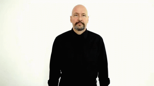 A Bald Man With A Beard Is Wearing A Black Shirt And Making A Hand Gesture GIF