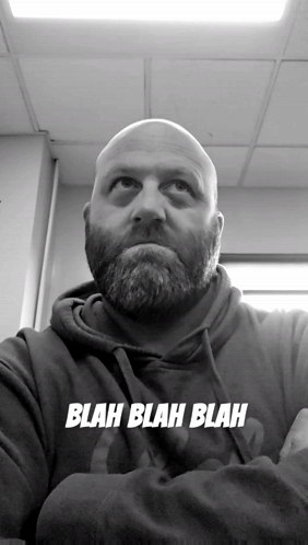 A Bald Man With A Beard Is Wearing A Blah Blah Blah Hoodie GIF