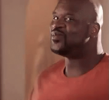 A Bald Man With A Beard Is Wearing A Red Shirt And Looking At The Camera . GIF