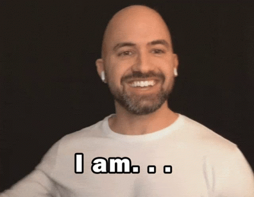 A Bald Man With A Beard Is Wearing A White Shirt That Says " I Am " On It GIF