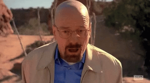 A Bald Man With A Beard Is Wearing Glasses And A Blue Shirt . GIF