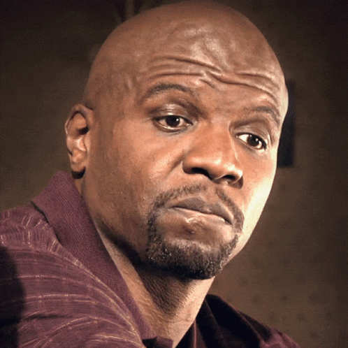 A Bald Man With A Beard Looks At The Camera With A Serious Look On His Face GIF