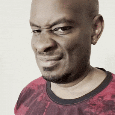 A Bald Man With A Beard Wearing A Red Shirt Makes A Funny Face GIF