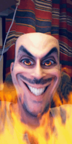 A Bald Man With A Mustache Is Smiling With Fire Behind Him GIF