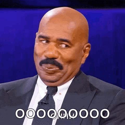 A Bald Man With A Mustache Is Wearing A Suit And Tie And Is Making A Funny Face . GIF