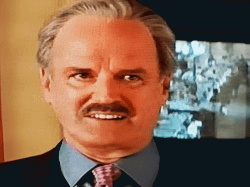 A Bald Man With A Mustache Wearing A Blue Shirt And Tie GIF