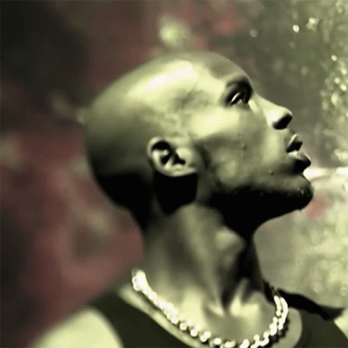 A Bald Man With A Necklace Around His Neck Is Looking Up GIF