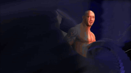 A Bald Man With A Tattoo On His Arm Is Standing In Front Of A Purple Background With The Name Bat On It GIF