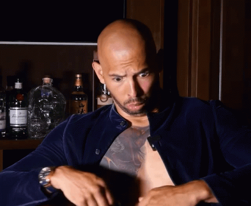 A Bald Man With A Tattoo On His Chest Holds A Bottle Of Budweiser GIF