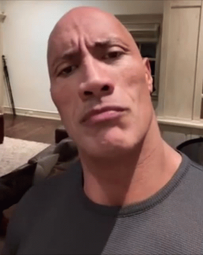 A Bald Man With A Very Large Head Looks At The Camera GIF