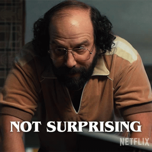 a bald man with glasses and a beard says not surprising