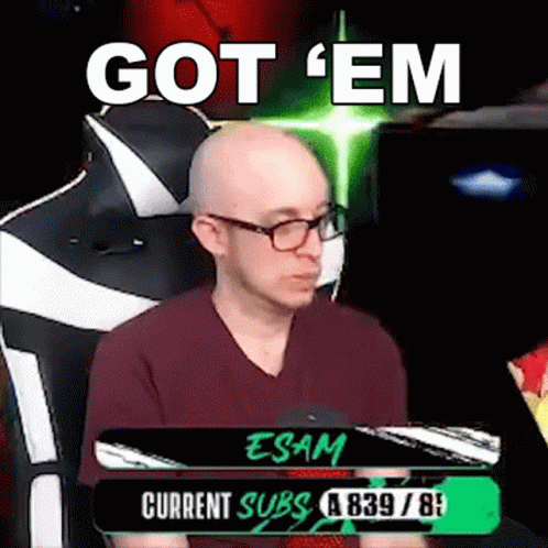 A Bald Man With Glasses Is Sitting In A Chair With The Words `` Got 'Em '' Written On The Screen . GIF