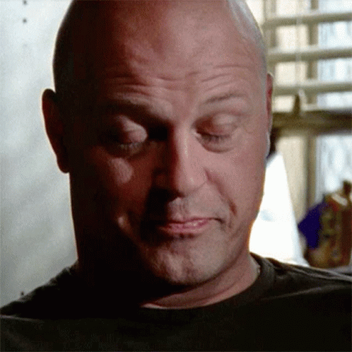 A Bald Man With His Eyes Closed Is Wearing A Black T-Shirt GIF