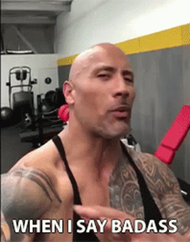 a bald man with tattoos is talking in a gym and says " when i say badass "