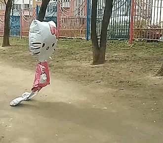 a balloon in the shape of a hello kitty is flying through the air .