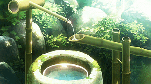 A Bamboo Fountain Is Pouring Water Into A Bowl GIF