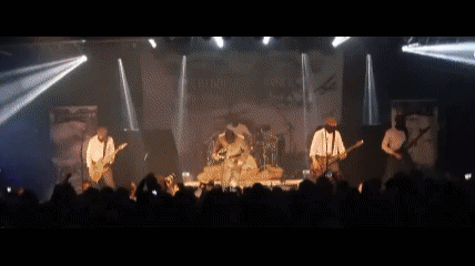 A Band Is Playing On Stage In Front Of A Crowd GIF
