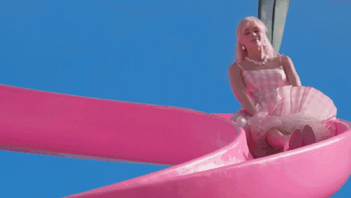A Barbie Doll Is Going Down A Pink Water Slide In A Swimming Pool GIF