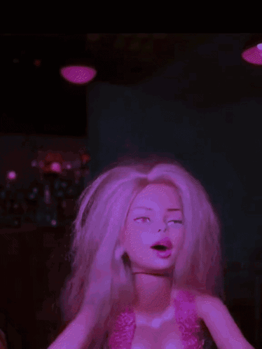 a barbie doll with blonde hair and a pink top