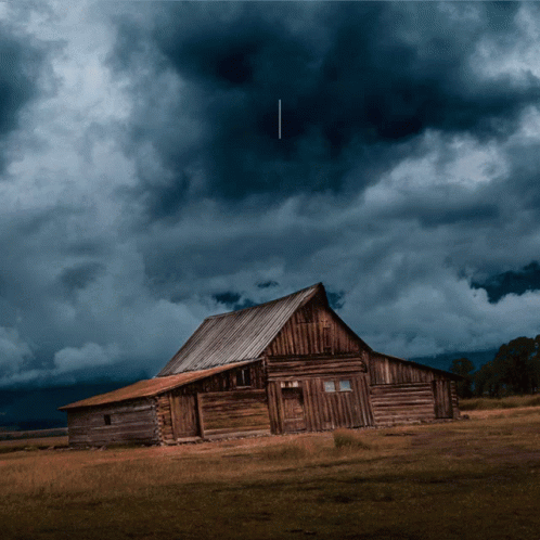 A Barn In A Field With A Dark Cloudy Sky Behind It GIF (480×480 ...