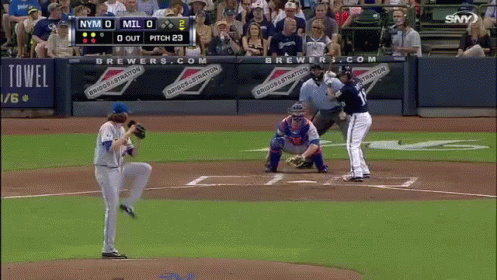 a baseball game is being played in front of a banner that says brewers