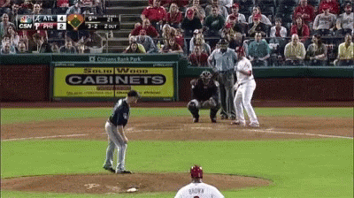 A Baseball Game Is Being Played In Front Of A Sign That Says Cabinets GIF