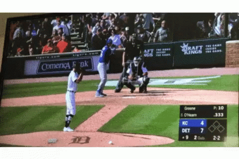 A Baseball Game Is Being Played In Front Of A Sign That Says Comienca Bank GIF