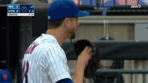 A Baseball Player Adjusts His Glove In The Dugout GIF