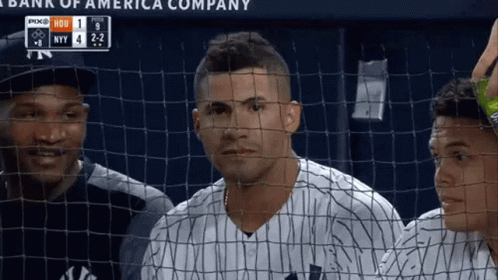 A Baseball Player Behind A Fence With A Scoreboard That Says Bank Of America Company On It GIF