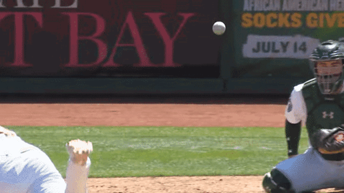 A Baseball Player Catches A Ball In Front Of A Sign That Says African American Relief Socks Give July 14 GIF