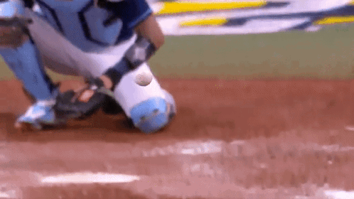 A Baseball Player Catching A Ball On A Field GIF
