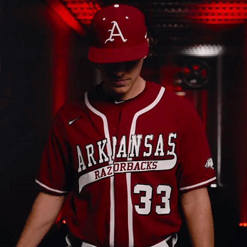A Baseball Player For The Arkansas Razorbacks Looks At The Camera GIF