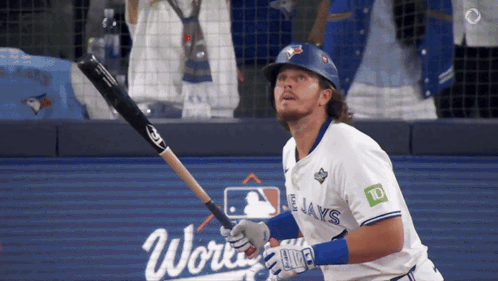 A Baseball Player For The Blue Jays Swings His Bat At The Ball GIF