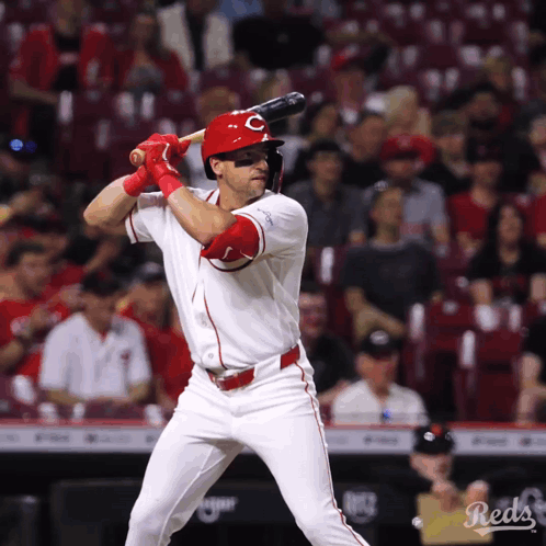 A Baseball Player For The Reds Is Swinging At A Ball GIF