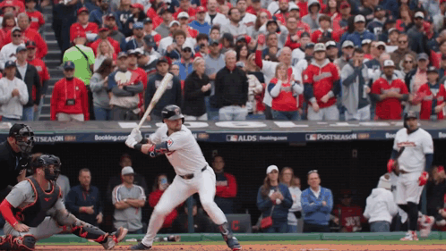 A Baseball Player Getting Ready To Hit A Ball In Front Of A Crowd With A Sign That Says Postseason On It GIF