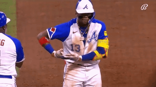 A Baseball Player In A Blue And White Uniform With The Number 13 On It GIF