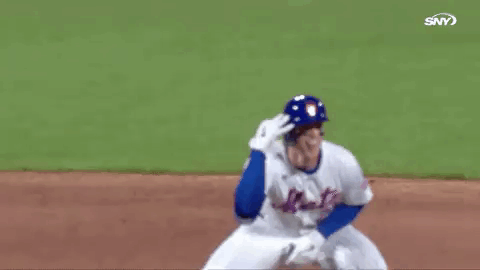 A Baseball Player In A Blue Helmet Is Kneeling On The Field And Waving . GIF