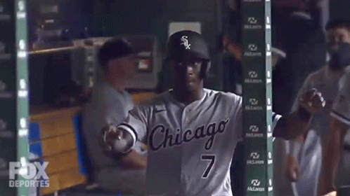 A Baseball Player In A Chicago Uniform Is Standing In The Dugout GIF