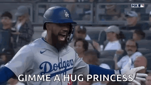A Baseball Player In A Dodgers Uniform Is Giving A Hug To A Fan . GIF