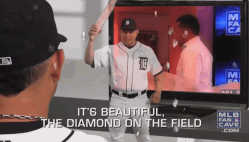 A Baseball Player In A Tigers Jersey Is Holding A Bat In Front Of A Tv Screen GIF
