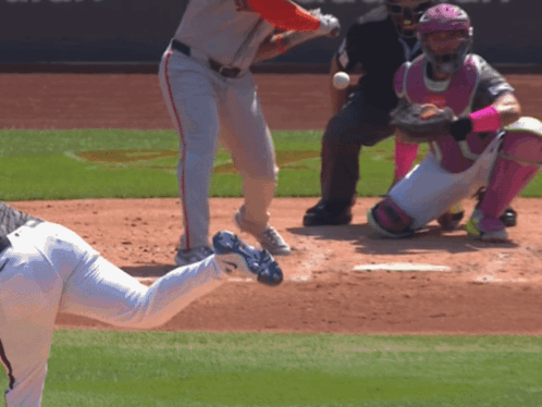 A Baseball Player In A White Jersey With A Red Hat Is About To Swing At A Ball GIF