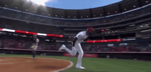 A Baseball Player In A White Uniform Is Running On A Field GIF