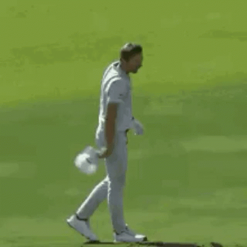 A Baseball Player In A White Uniform Is Standing On A Field . GIF