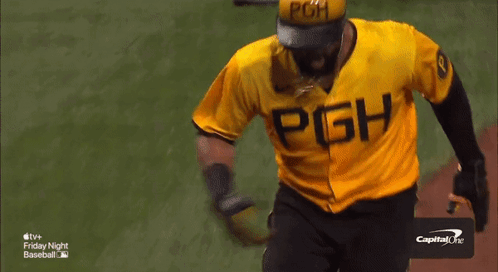 A Baseball Player In A Yellow Uniform Is Being Congratulated By A Group Of People GIF