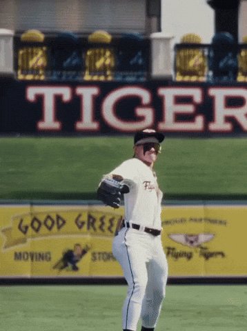 A Baseball Player In Front Of A Large Tiger Sign GIF