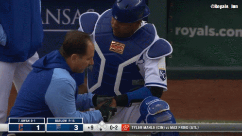 A Baseball Player Is Being Examined By A Doctor On The Field GIF