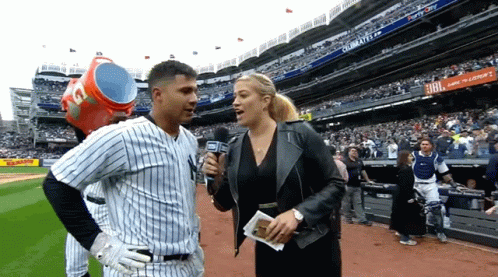 A Baseball Player Is Being Interviewed By A Woman With A Microphone In A Stadium With A Jbl Ad In The Background GIF