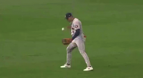 A Baseball Player Is Catching A Ball On The Field . GIF