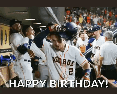 A Baseball Player Is Celebrating His Birthday In The Dugout While His Teammates Congratulate Him . GIF