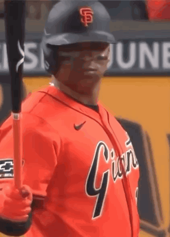 A Baseball Player Is Holding A Bat And Wearing An Orange Jersey That Says Giants GIF